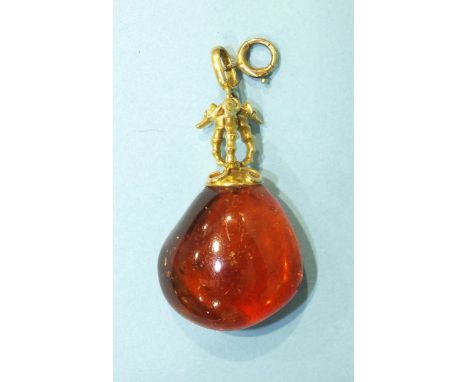 An unusual amber pendant, the gold finial in the form of three sea horses, on bale and ring-bolt, marked 9ct, 60mm overall, 9