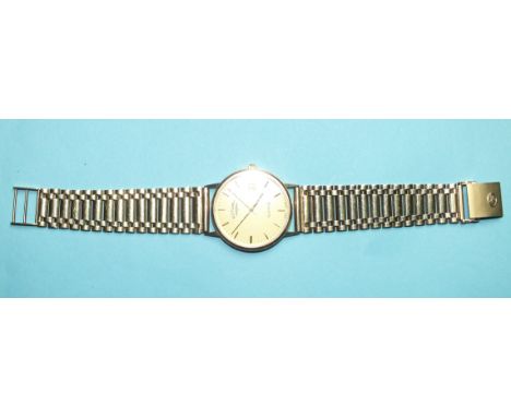 A Rotary quartz 9ct gold wrist watch with gold tone dial, date aperture and baton numerals, case diameter 33mm, on 9ct gold b