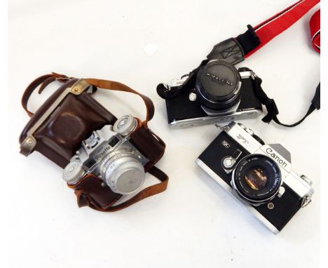Quantity of cameras and lenses including a Pentax Asahi ME SLR camera, a Canon FTQL SLR camera, a Braun Superpaxette camera, 
