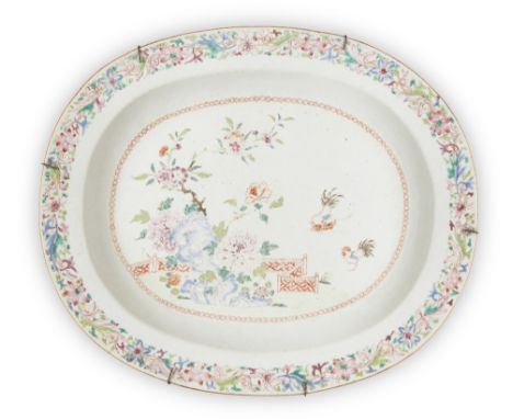 A Chinese famille rose 'chickens' oval platter, Qianlong period, painted with flowers rockwork and two chickens in a fenced g
