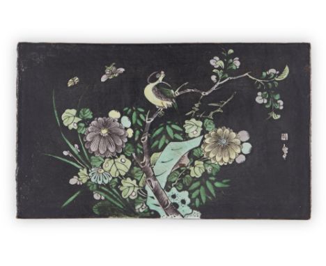 A Chinese black ground famille verte biscuit tile, 19th century, enamelled with a magpie amongst blossoming flowers beside a 