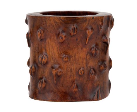 A Chinese huanghuali tree trunk-form brush pot, bitong, 18th century, the cylindrical pot naturalistically carved to simulate