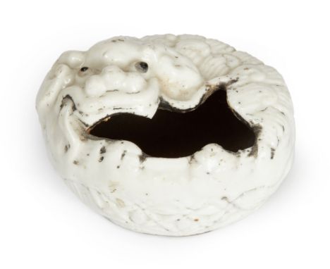 A Chinese white-glazed 'lion' water pot, 18th century, modelled as a recumbent Buddhist lion with black enamel eyes, 6.5cm wi