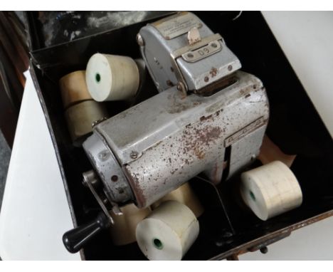 A vintage bus conductor's ticket machine in tin box & with ticket reels