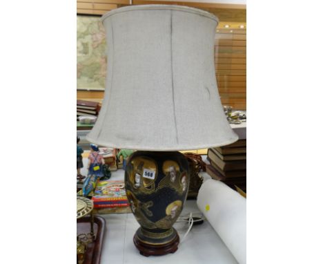 A ceramic gilt & black painted table lamp decorated with Oriental heads