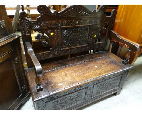 A carved oak box seat monk's bench
