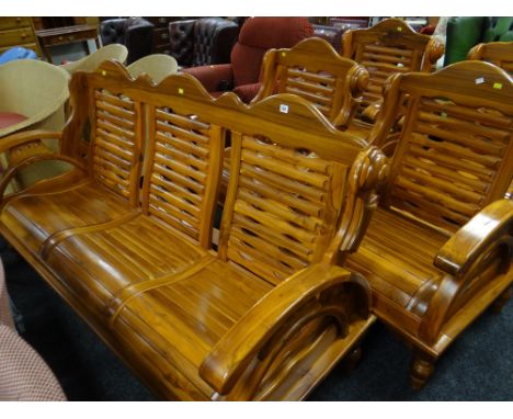 A hand crafted Malaysian teak three-seater sofa together with a similar matching armchair