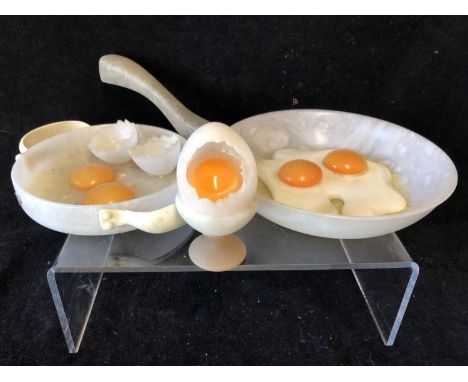 Marco Ricciardi, Alabaster sculptures formed as fried eggs in a frying pan; egg cup with cracked egg; and eggs and shells on 