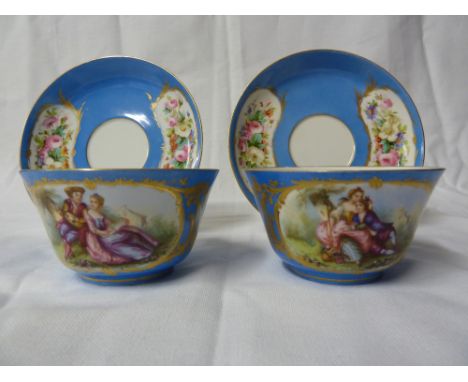 A pair of 'Sevres' tea cups and saucers, the blue celeste ground with reserves of summer flowers and rural lovers, printed an