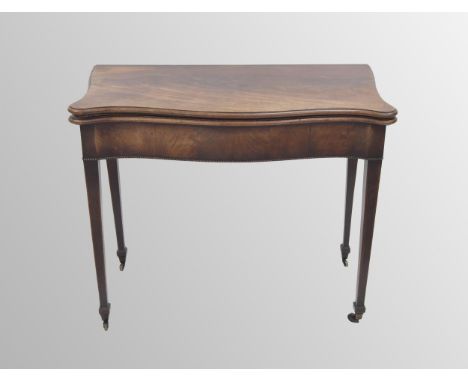 George III mahogany serpentine foldover card table, the hinged top enclosing a velvet cream lined interior over the plain fri