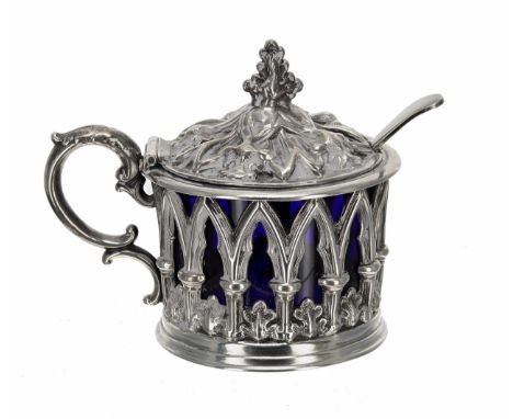 Victorian silver drum mustard, with a hinged cover and cast open arcaded surround enclosing a blue glass liner, maker Henry W