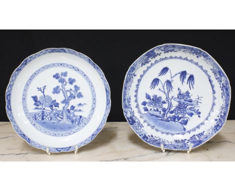 Pair of Chinese export blue and white porcelain circular plates, decorated with boats in a landscape within butterfly and scr