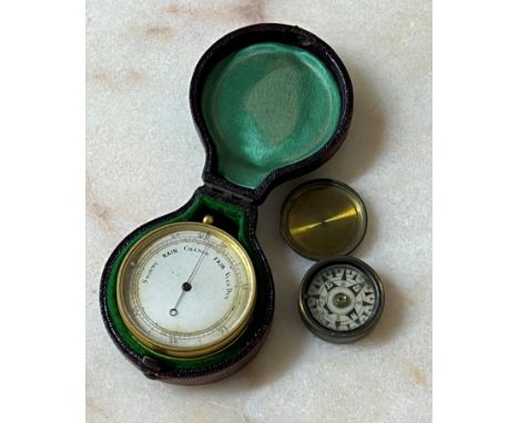 Gilded pocket barometer with a silvered dial and compass set to the reverse, in a Morocco leather case, 48mm diameter; with a