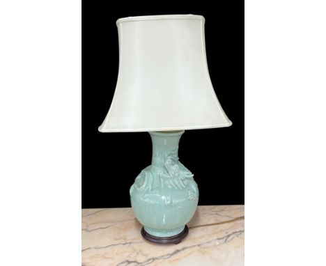 Chinese celadon glaze porcelain table lamp, decorated in relief with a dragon, with shade, the lamp base 17" high, 30" high o