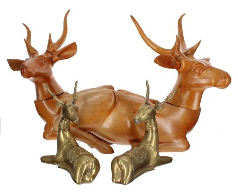 Pair of brass recumbent elk figures,&nbsp;8" high; together with a pair larger carved treen recumbent deer figures, 18" wide,