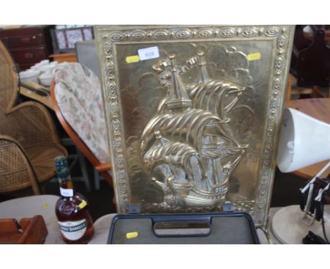 A brass embossed firescreen depicting a ship at sea 