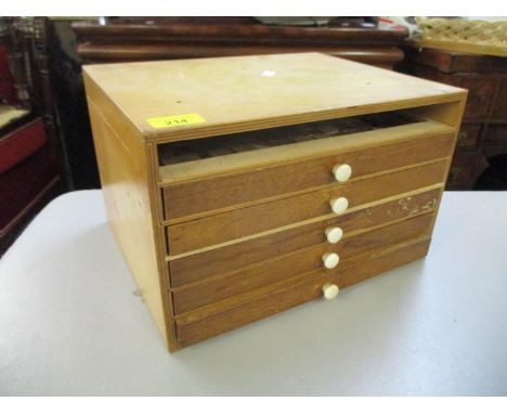 An early 20th century table top collectors chest with five drawers containing various watch components and tools to include C