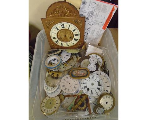 A selection of enamel, brass and metal clock dials, along with a French porcelain clock plaque in the style of Sevres mounted
