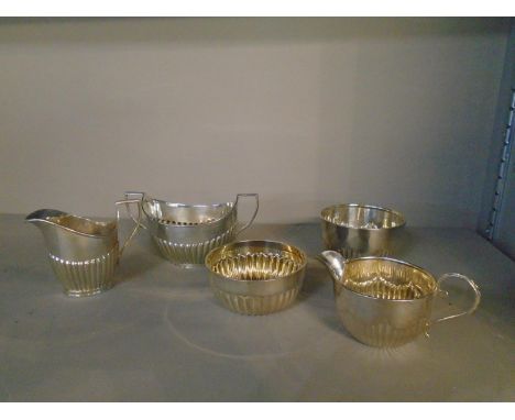 A matched silver three-piece part tea set, London shape with fluted decoration, comprising a small cream jug, Mappin and Webb