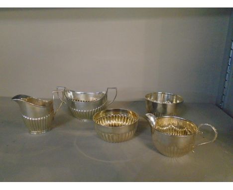 A matched silver three-piece part tea set, London shape with fluted decoration, comprising a small cream jug, Mappin and Webb