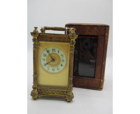 A late 19th century brass cased carriage clock with a fitted leather travel case. The enamel dial having Arabic numerals and 