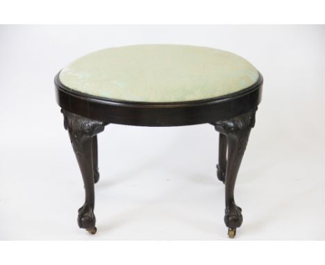 A George II style carved mahogany oval stool, with drop in seat on acanthus leaf carved cabriole legs and claw and ball feet,