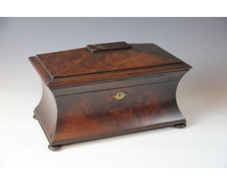 A Regency mahogany sarcophagus shaped tea caddy, of concave form,  with hinged lid enclosing two canisters and repaired mixin