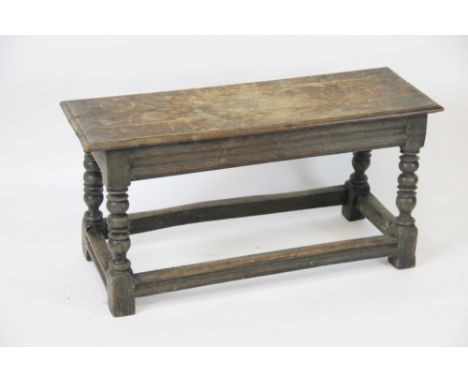 A late 17th / early 18th century oak join stool, of long proportions, three plank top with a moulded edge, on turned legs wit