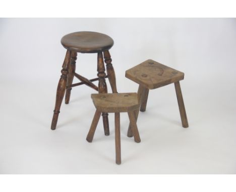 A late 19th century ash stool, with circular seat, 51cm H, with two smaller oak milking stools (3)