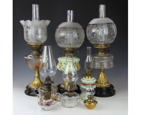 Three Victorian oil lamps, one with a frilled and frosted glass shade, the other two with globe shades, each with a glass res