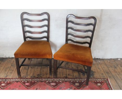 A set of four George III mahogany dining chairs, with shaped five bar ladder backs and stuff-over seats on chamfered legs (4)
