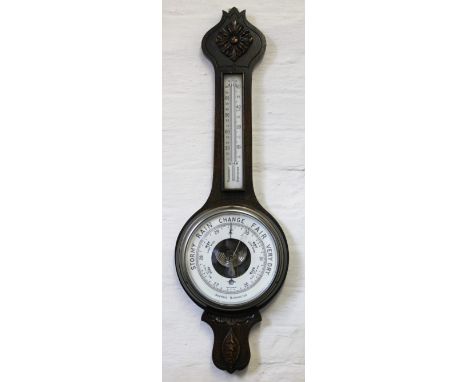 A 1920's carved oak aneroid barometer, the dial named for C. H. Moody & Sons High St Crewe, 80cm