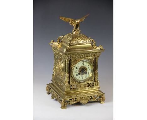A late 19th century cast brass eight day clock, ceramic Arabic chapter ring and movement striking on a gong, the square case,