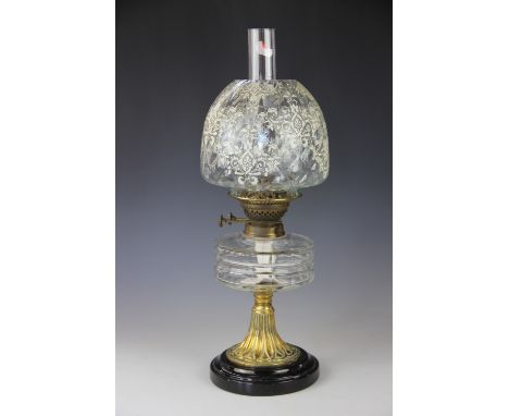 A Victorian oil lamp, with floral decorated dimpled glass shade, glass reservoir and brass base, 46cm to the top of the shade