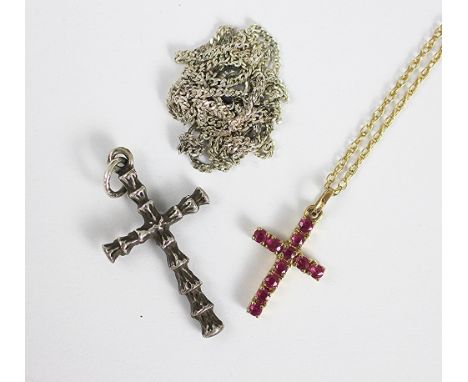 A 9ct yellow gold and ruby set cross pendant with attached chain, and a white metal cross pendant (2)