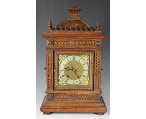 A late 19th century inlaid oak quarter striking mantel clock, silvered Roman numeral chapter ring engraved by retailers H Rob