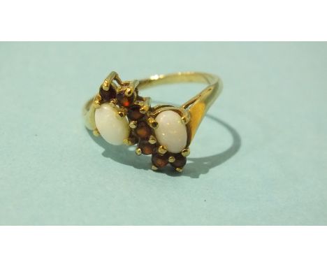 A 9ct gold cross-over ring set opal and garnets, size P, 2.7g.