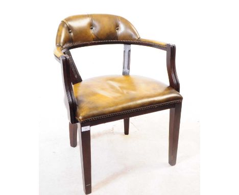 A 20th century leather and mahogany captains office desk chair. Raised on tapering legs with green leather upholstered seat a