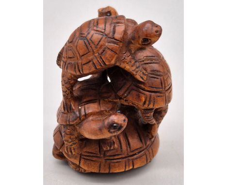 Japanese hand carved boxwood netsuke of a family of five turtles standing on each others shells. All having black bead eyes a