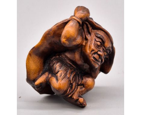 Japanese hand carved boxwood netsuke of an Oni Monster hiding from the sun. Signed. [4cm high] 