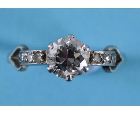 An Art Deco platinum and diamond solitaire ring, with diamond set shoulders, approx ring size Q  See inside back cover colour