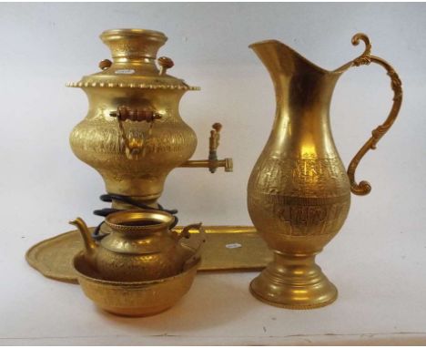 A Middle Eastern gold plated ewer, with embossed decoration, 37 cm high, two matching bowls, a samovar and a tray, silver pla