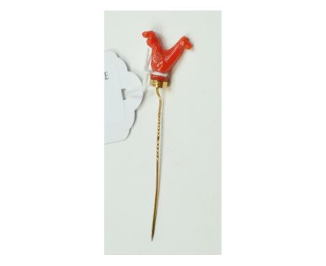 A stick pin, the coral finial in the form of an animal