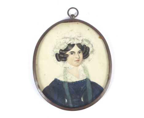 An early 19th century portrait miniature of a lady. Watercolour, gouache on paper, depicted wearing a laced bonnet and blue d