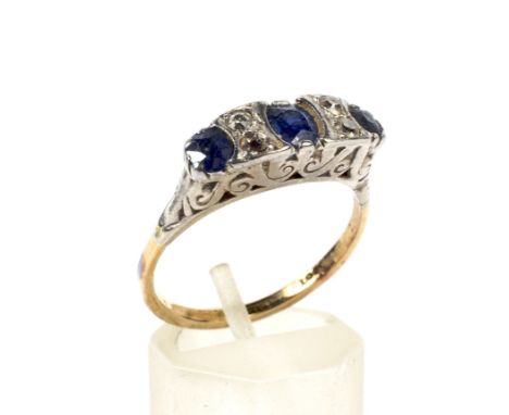 An early 20th century gold, sapphire and diamond carved half-hoop ring. The three graduated oval mixed-cut sapphires spaced b