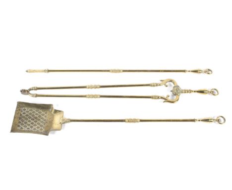 A Regency style brass fire companion set. Comprising: tongs, shovel and pocker, with urn finials and ring tops, 73.5cm long 