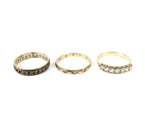 Three rings. Comprising a 9ct bi-colour gold and green paste eternity ring, obscured hallmarks probably London 1967, size S, 