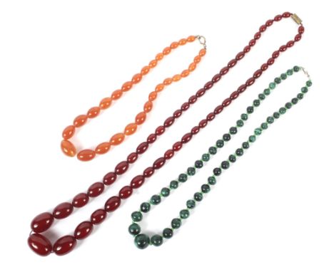 Three bead necklaces, comprising; an imitation red-amber oval bead necklace of 55 oval beads graduating from approx. 27mm x 1
