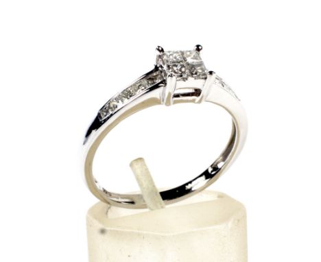 A modern 18ct white gold and princess diamond dress ring. The head claw and invisibly set with a cluster of four stones, betw