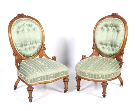 A pair of Victorian satin birch salon chairs. WIth carved rose crest and button back upholstery, on waisted reeded legs and c